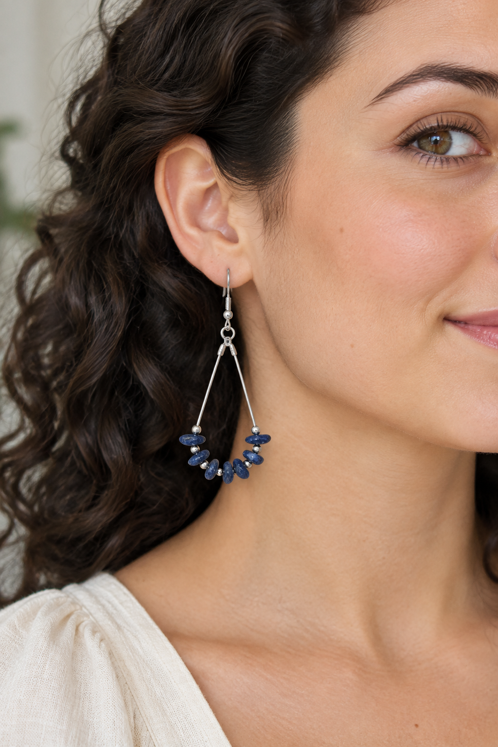 Close-up model wearing a blue earring