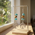 Earth and Water earrings hanging on a jewelry stand