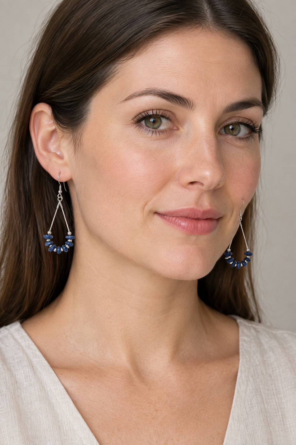 Model wearing smaller blue teardrop earrings