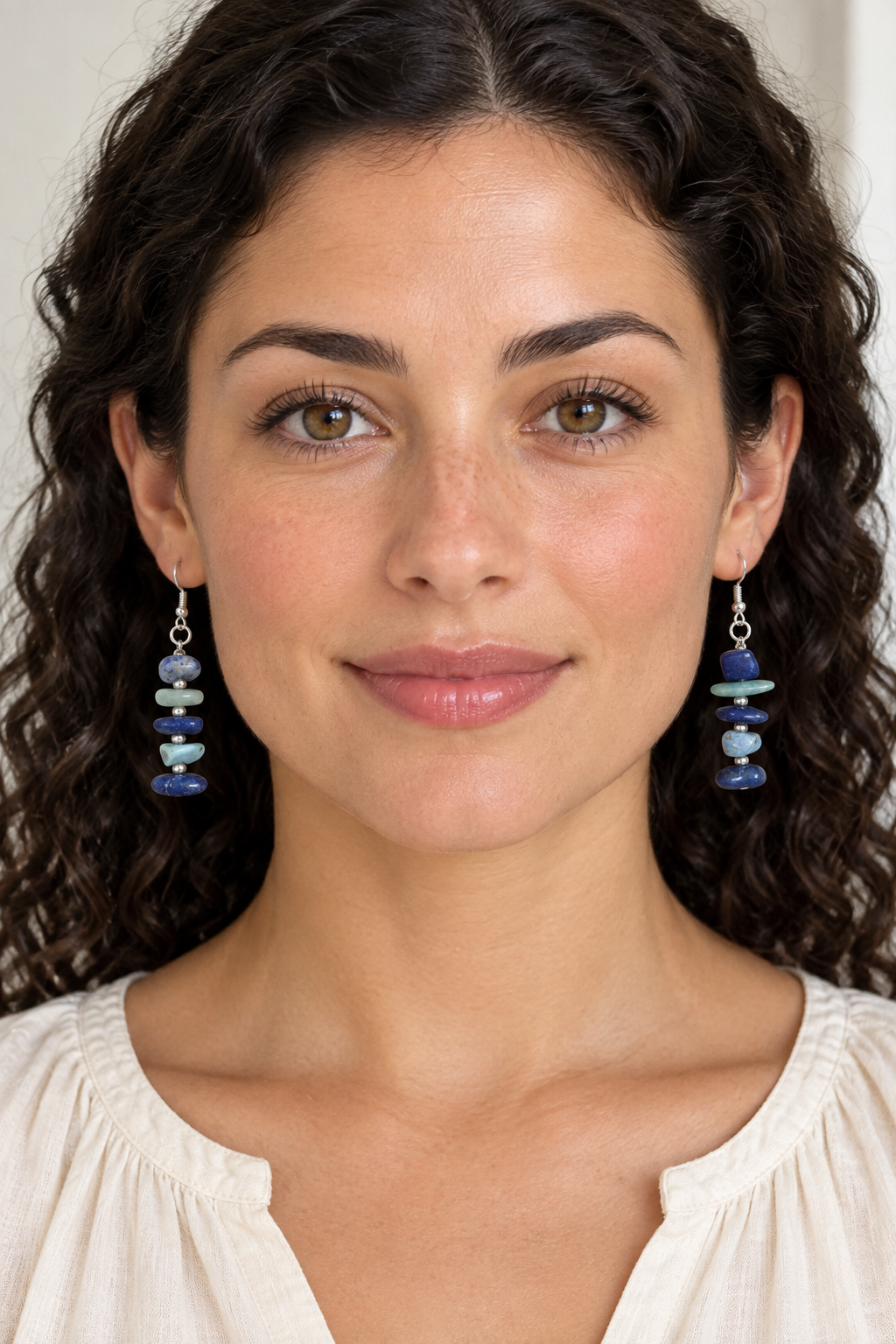 Model wearing the blue-and-green earrings