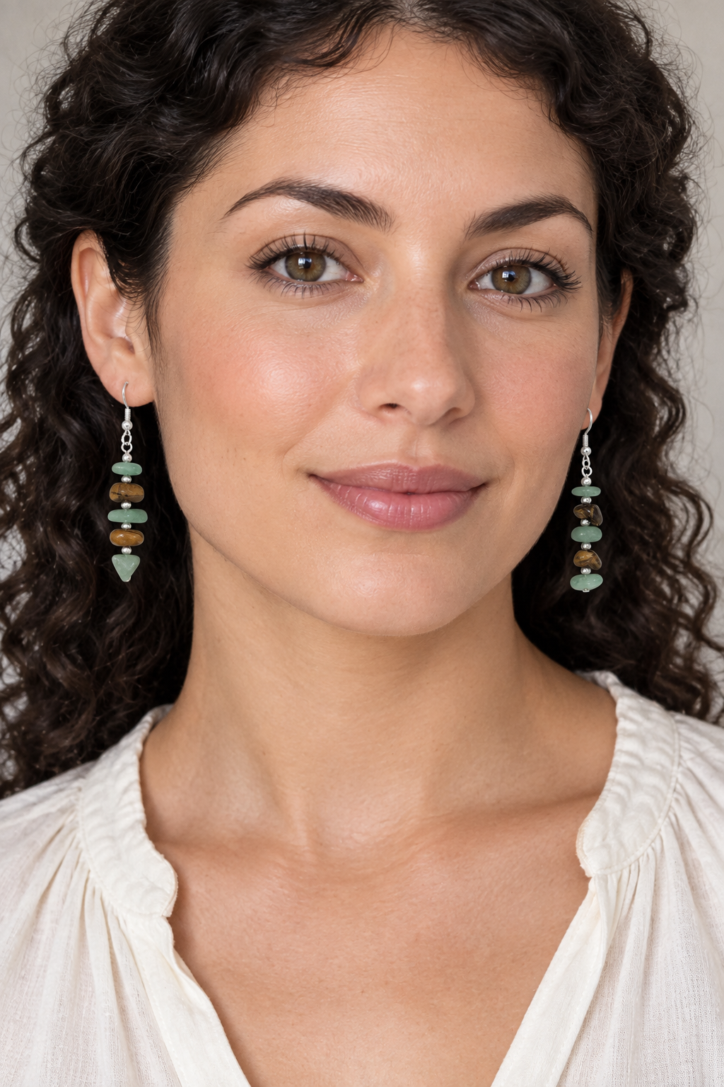 Model wearing the green-and-brown earrings