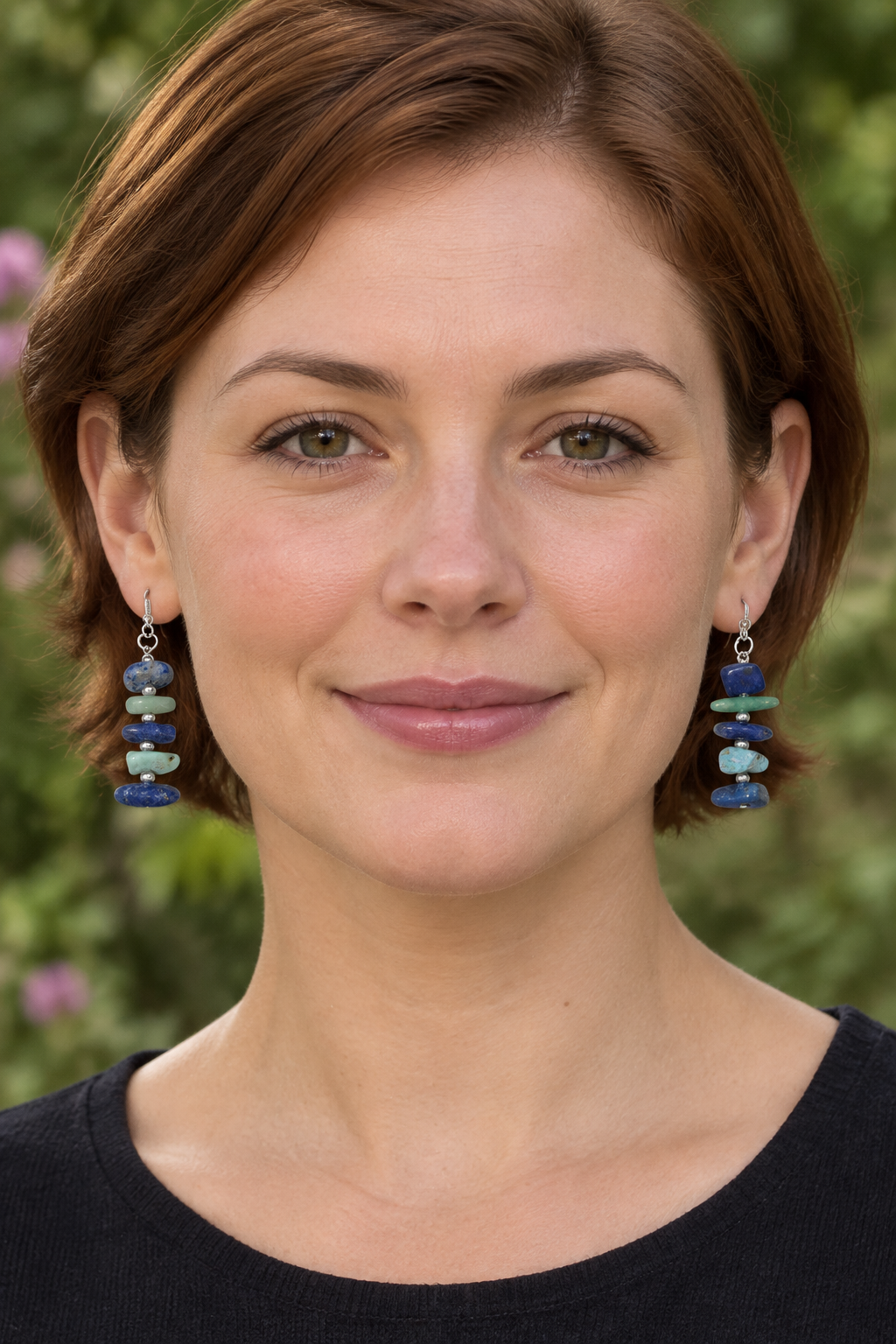 Second model wearing the blue-and-green earrings